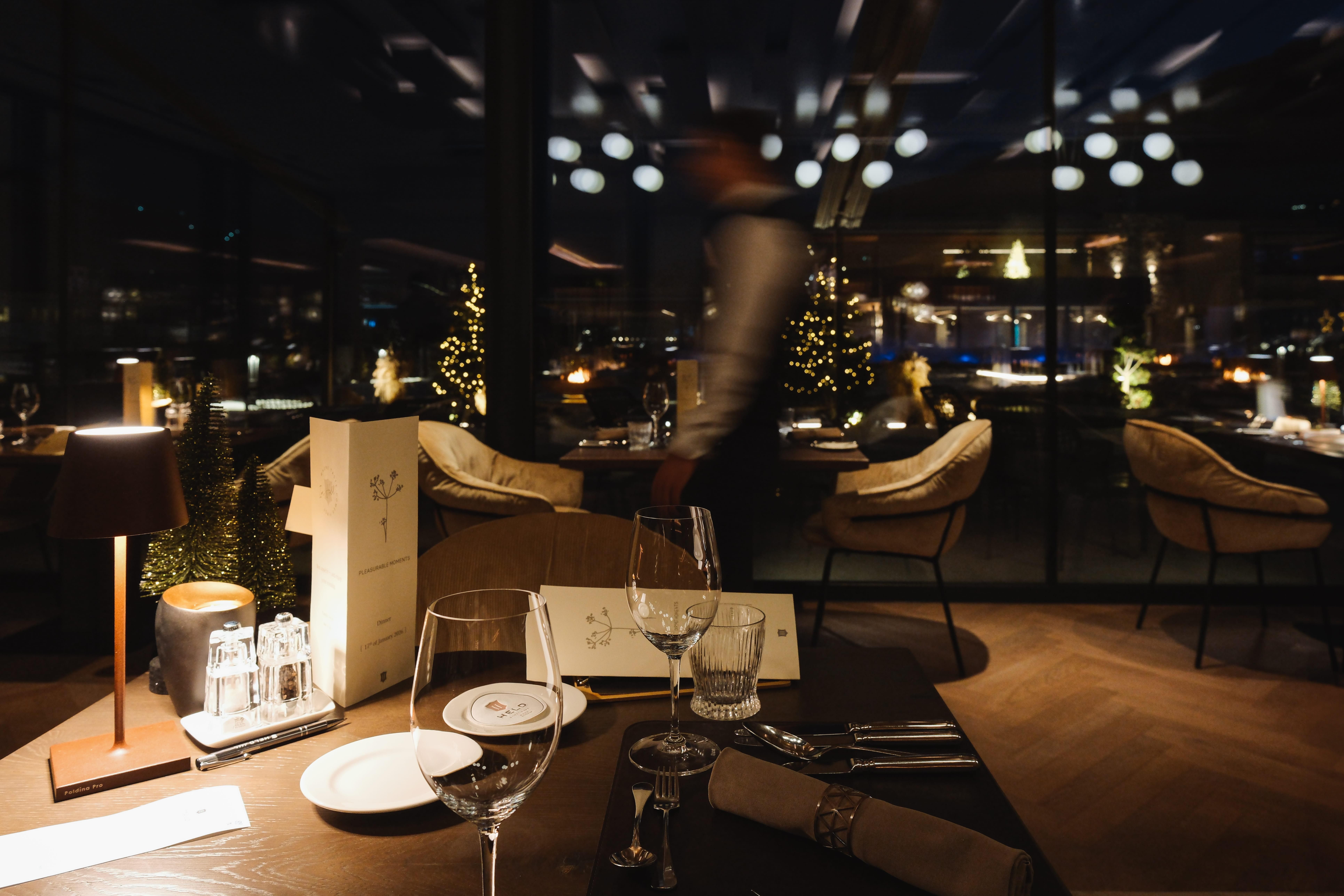 An elegant restaurant at night with soft lighting.
Set tables and wonderful views create a cozy atmosphere.
