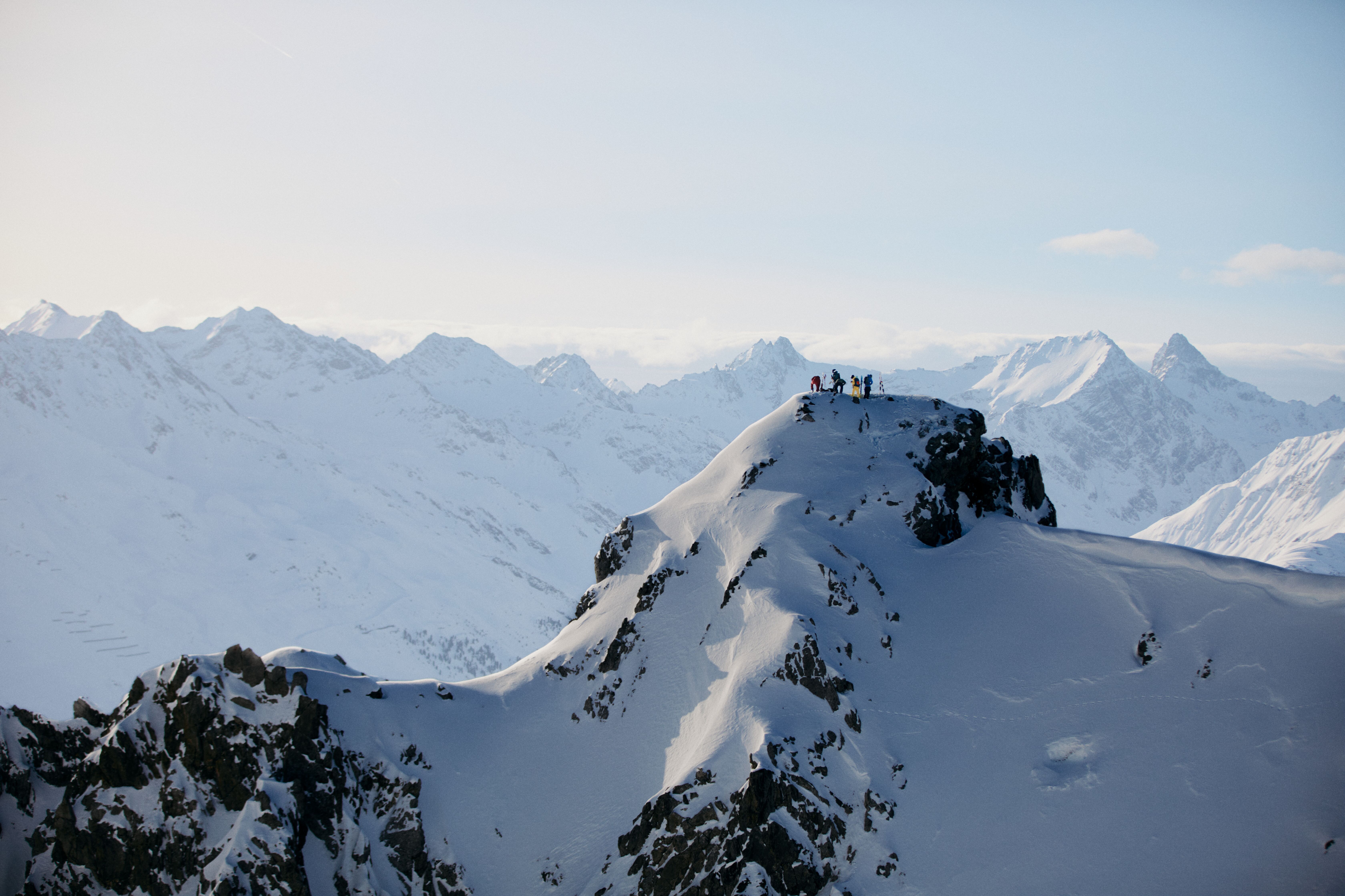 Skifahrer stehen am Gipfel des Schindlergrats und bereiten sich auf die Abfahrt vor.