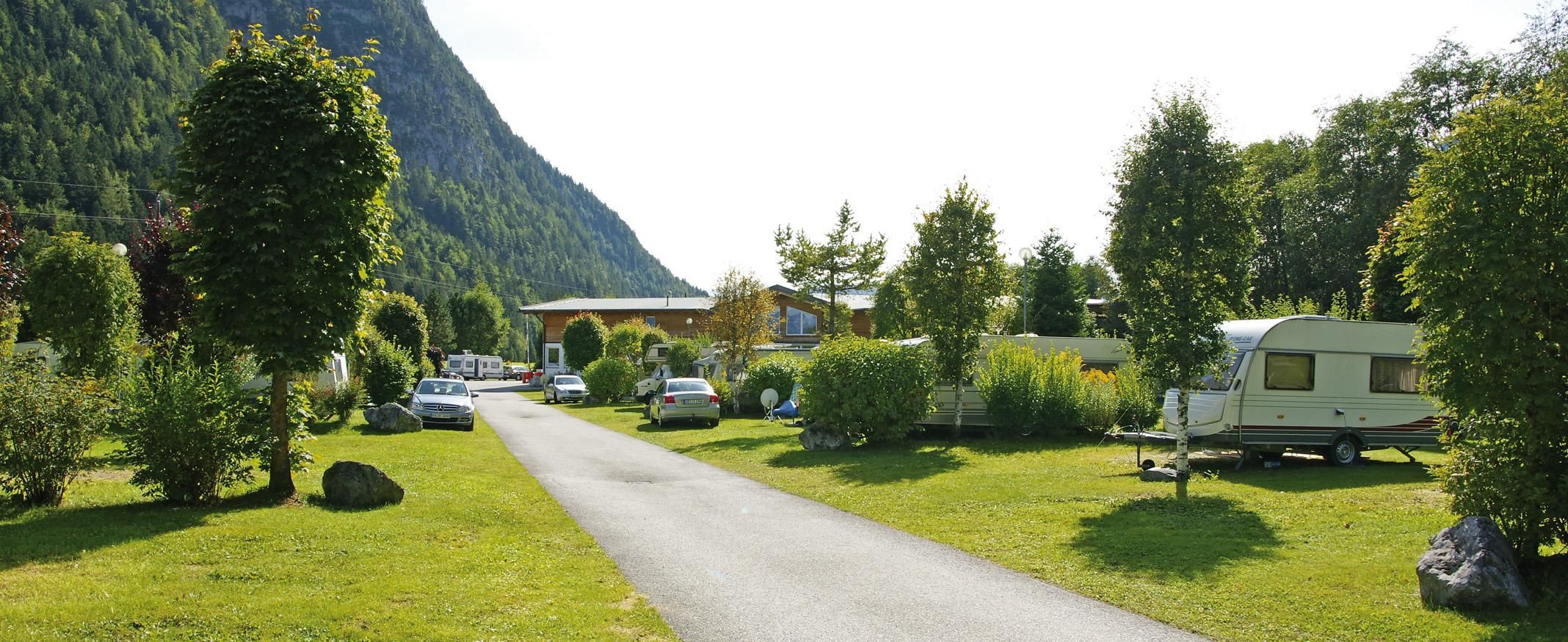 A beautiful campsite with caravans and lots of greenery. Surrounded by mountains and trees, it offers a peaceful atmosphere.