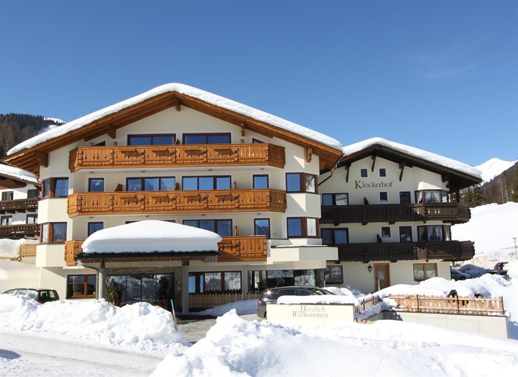 A charming hotel in the snow with traditional wooden balconies. The surroundings are wintry and picturesque.
