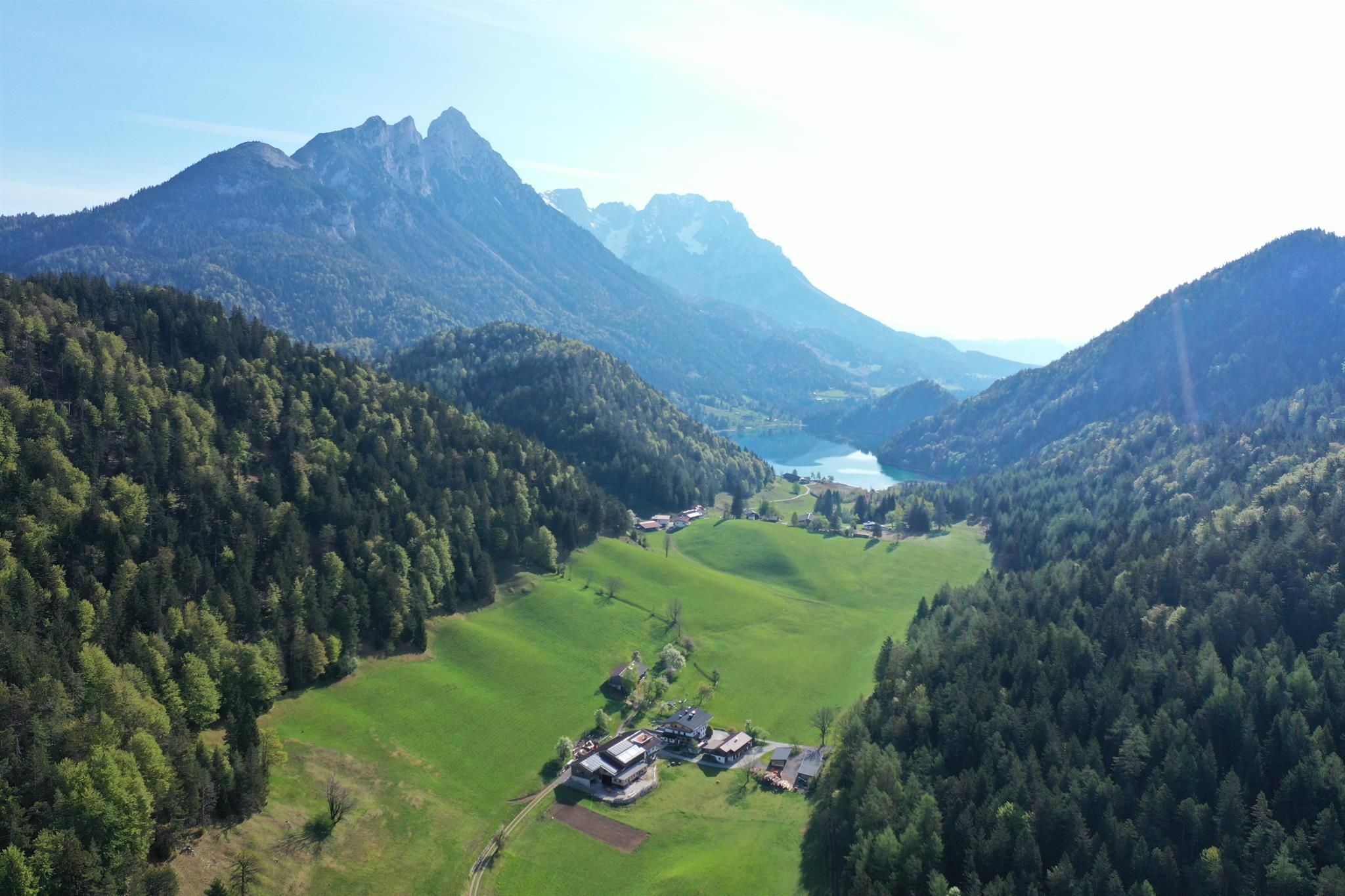 A picturesque landscape with green meadows, mountains, and a clear lake. The natural beauty of the surroundings radiates tranquility and peace.