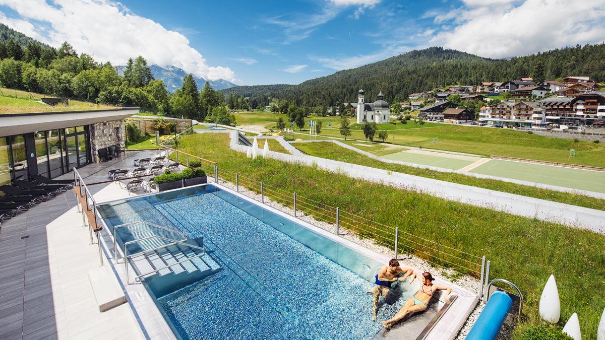 Une île rocheuse avec fontaine, un toboggan aquatique de 140 mètres de long, une piscine extérieure chauffée, des tables de massage sous-marines – la partie aquatique du Centre des sports et des congrès de Seefeld allie divertissement et détente. Un vaste espace sauna permet de s’adonner à des sudations bienfaisantes., © Region Seefeld, Andre Schönherr