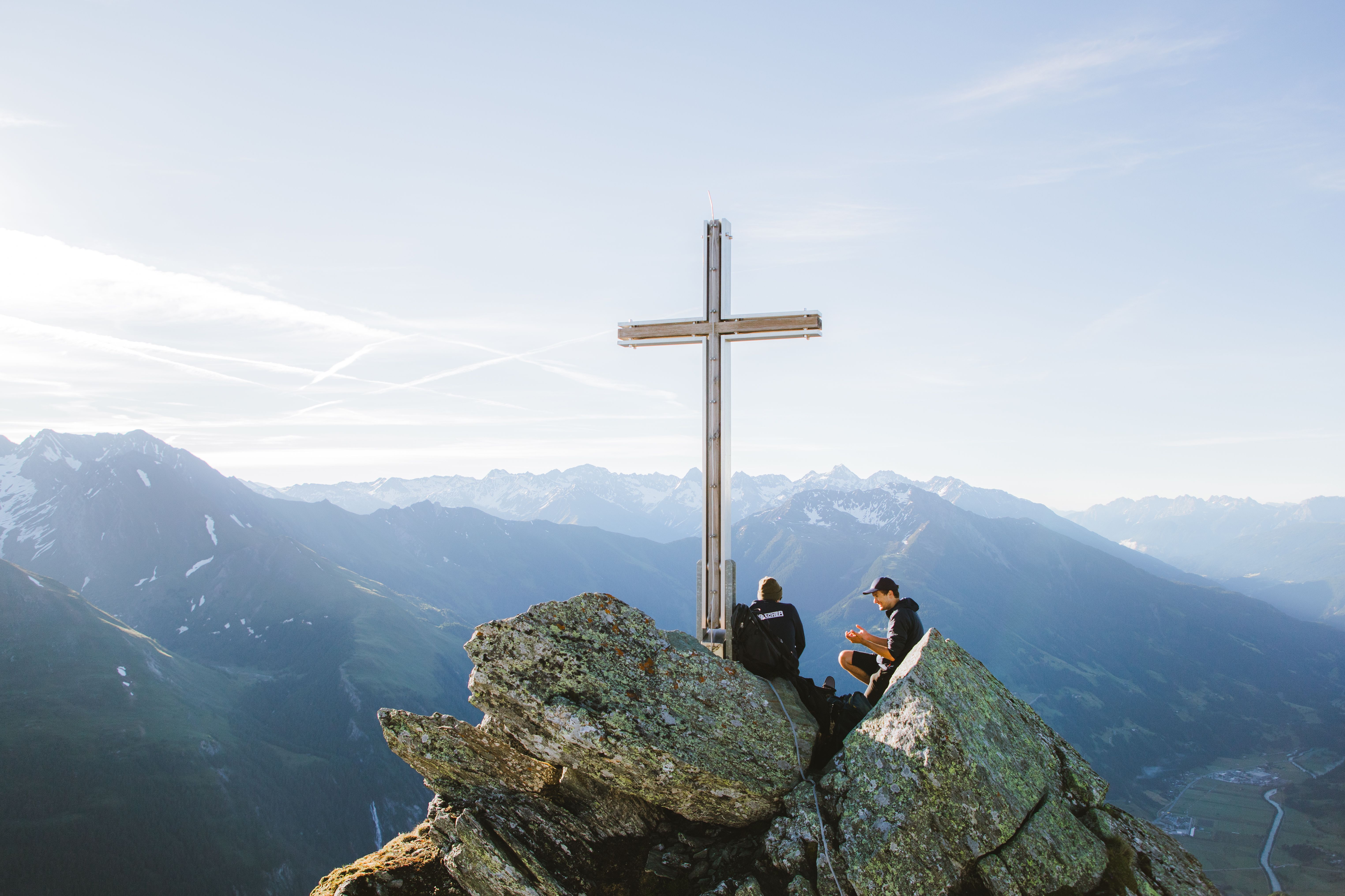 Zwei Jungs gönnen sich eine Jause am Gipfelkreuz